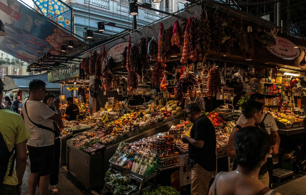 Boqueria market stall with hanging garlic, peppers and fresh produce