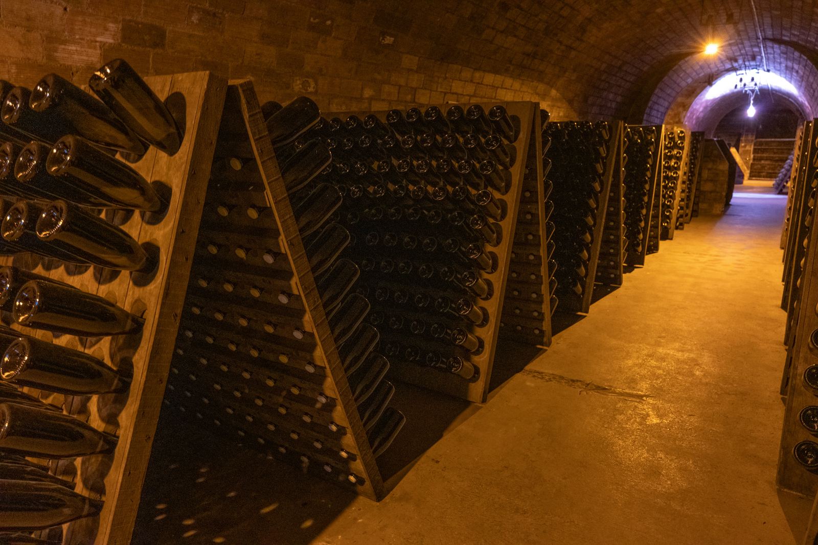 Riddling racks of cava bottles in an underground brick cellar