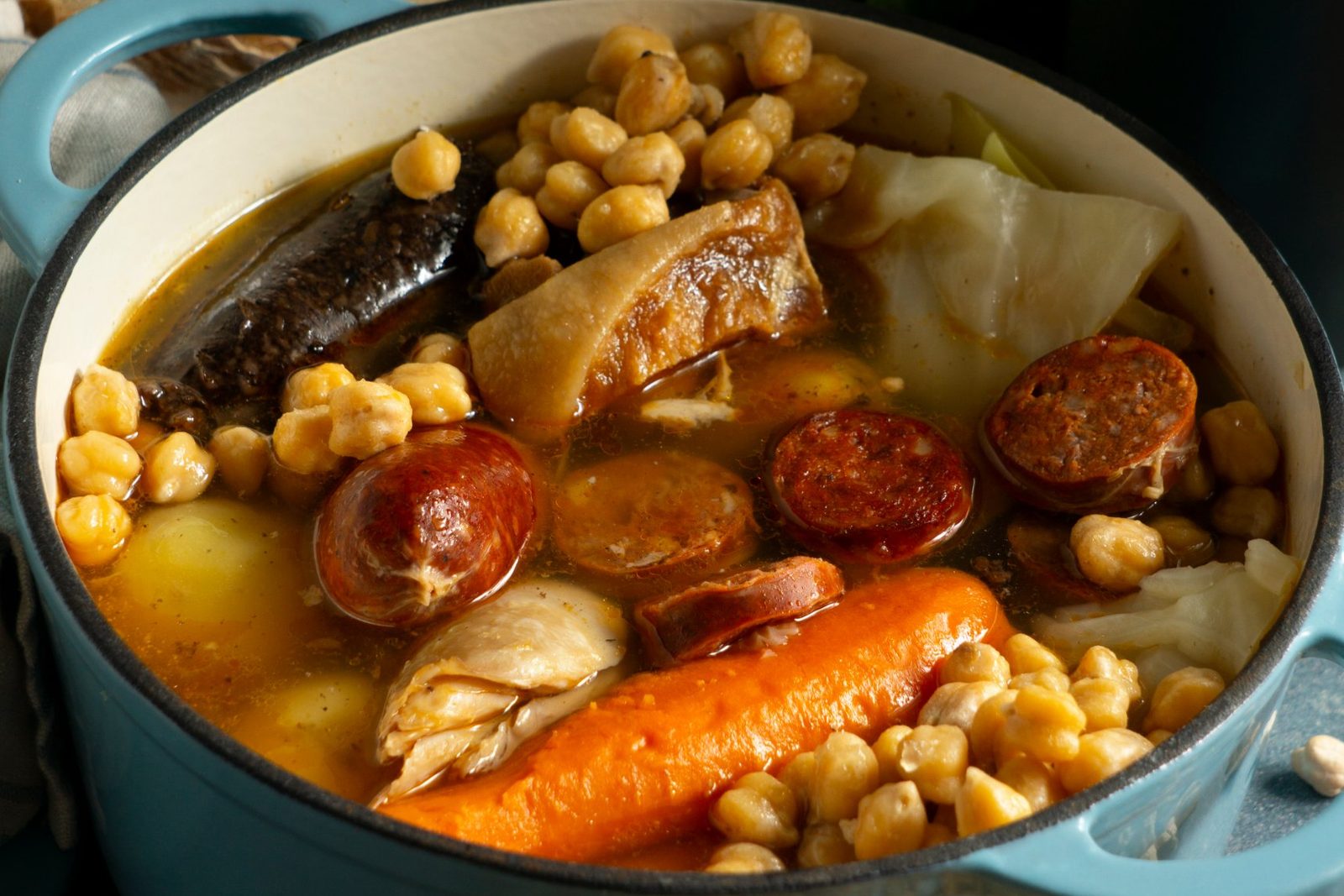 A pot of cocido madrileño with chickpeas, chorizo, morcilla and vegetables