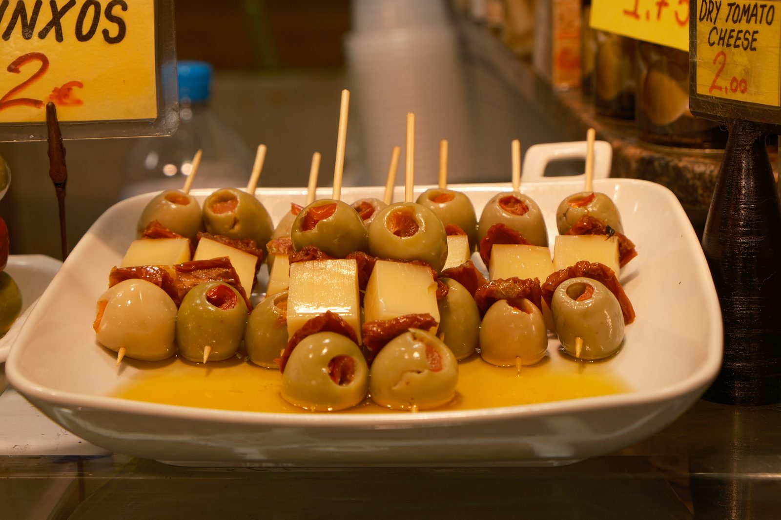 Gilda and boquerón pintxos on toothpicks at a Spanish bar counter