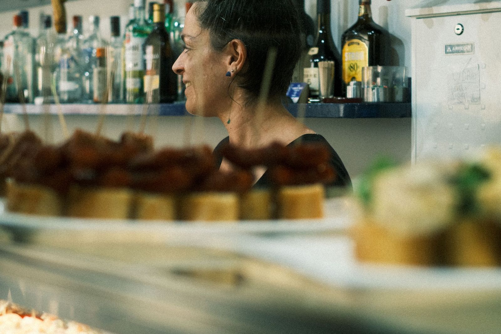 A bartender behind a pintxos counter in San Sebastián