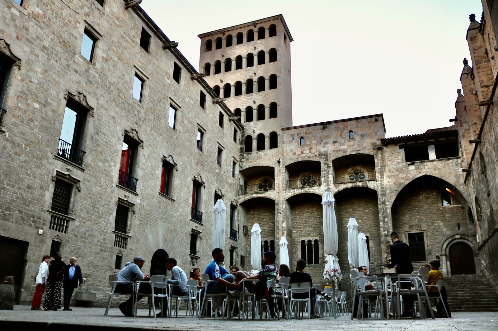Stone courtyard of Plaça del Rei in the Barcelona Gothic Quarter with outdoor cafe seating