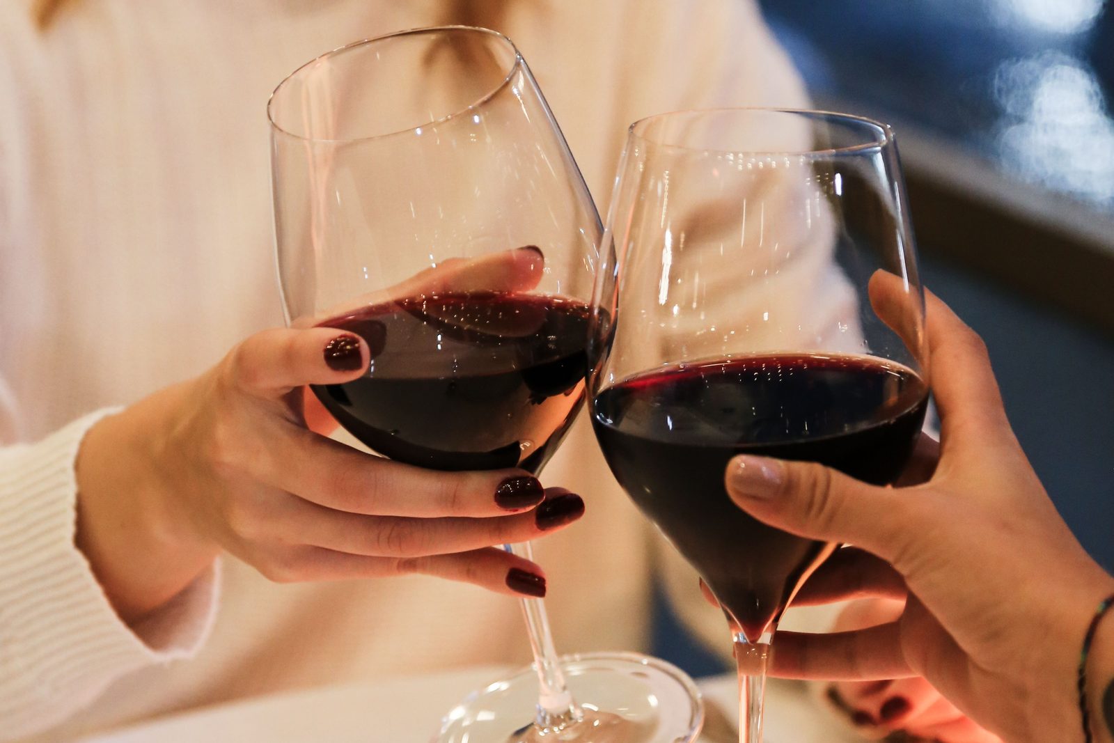 Two glasses of red wine raised in a toast