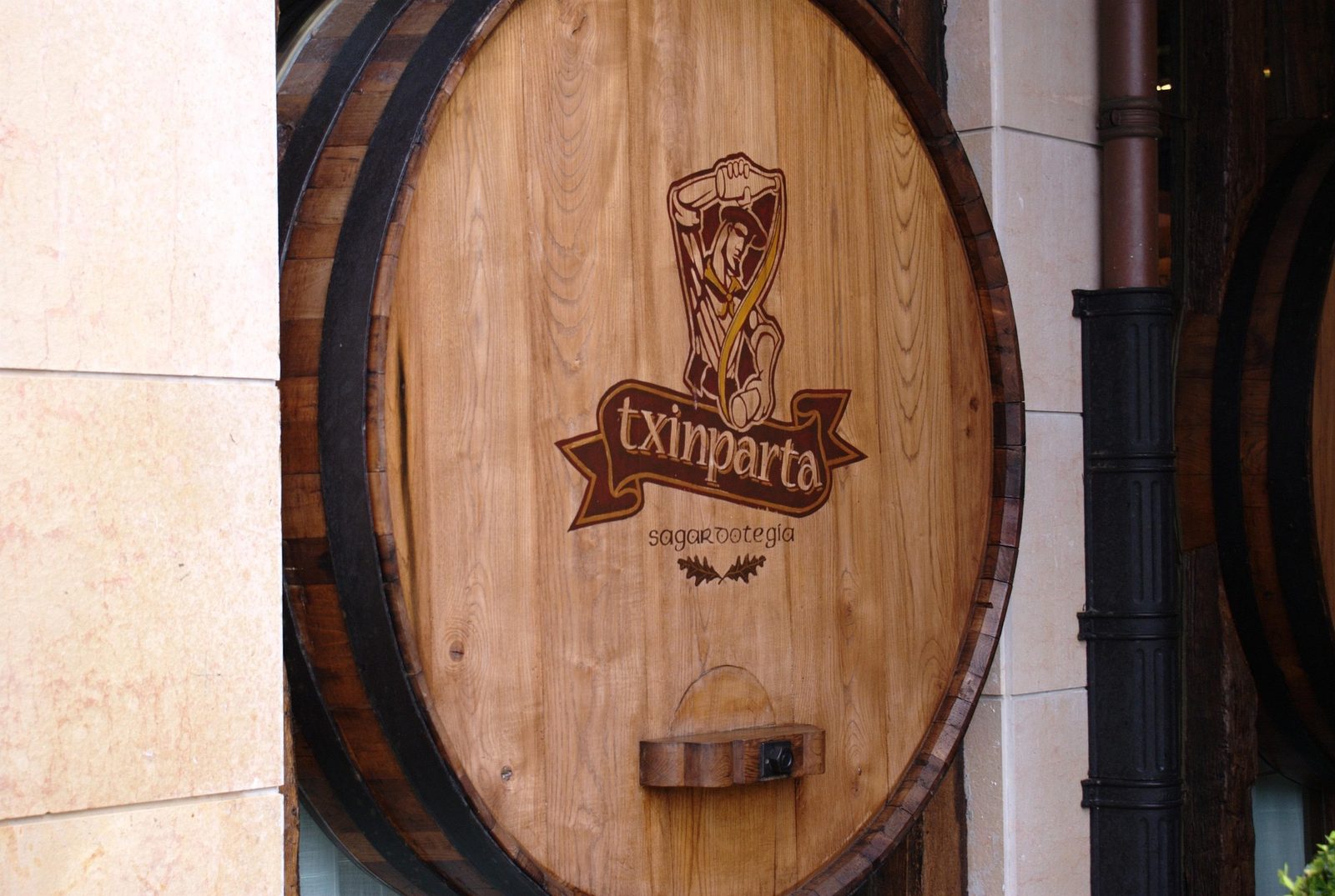 A large oak cider cask outside a Basque sagardotegia